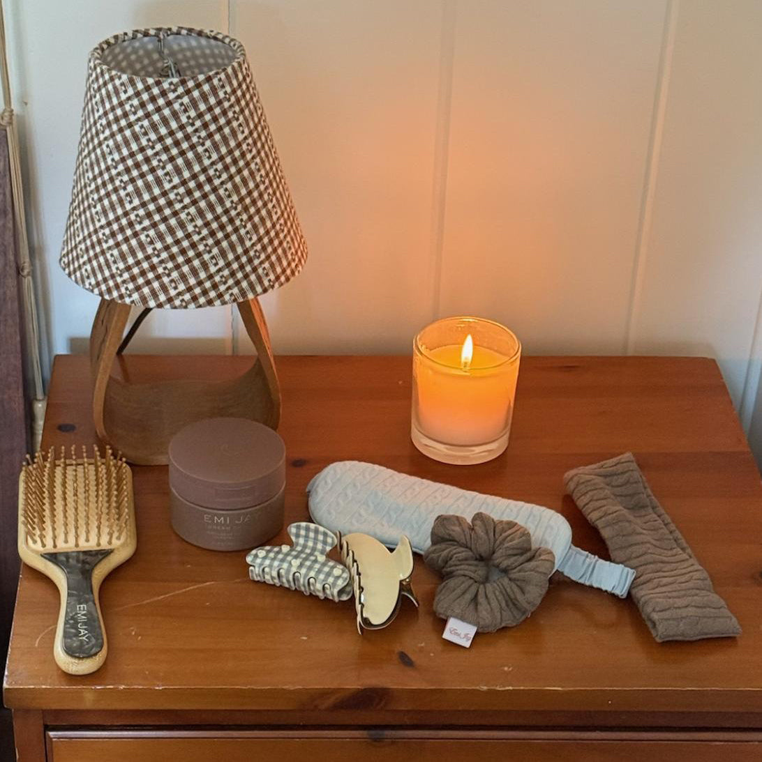 Cozy Scrunchie in Heather Cloud Knit on side table with assorted hair care and accessories