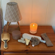 Cozy Scrunchie in Heather Cloud Knit on side table with assorted hair care and accessories