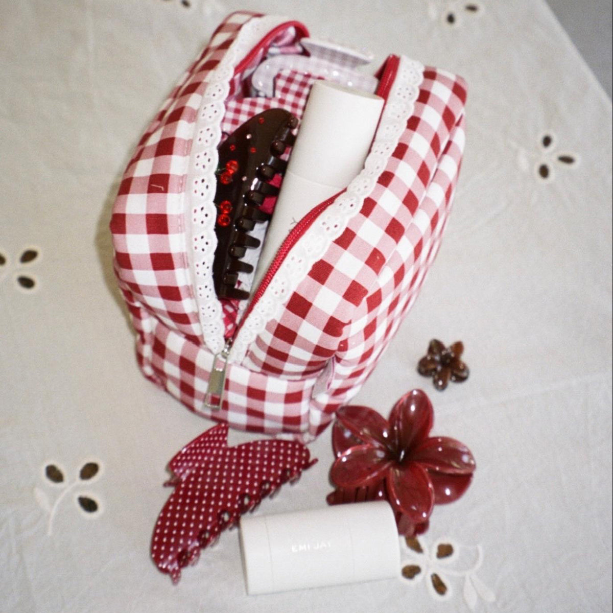 Gingham Pouch in Cherry Kiss with assorted emi jay accessories and hair care