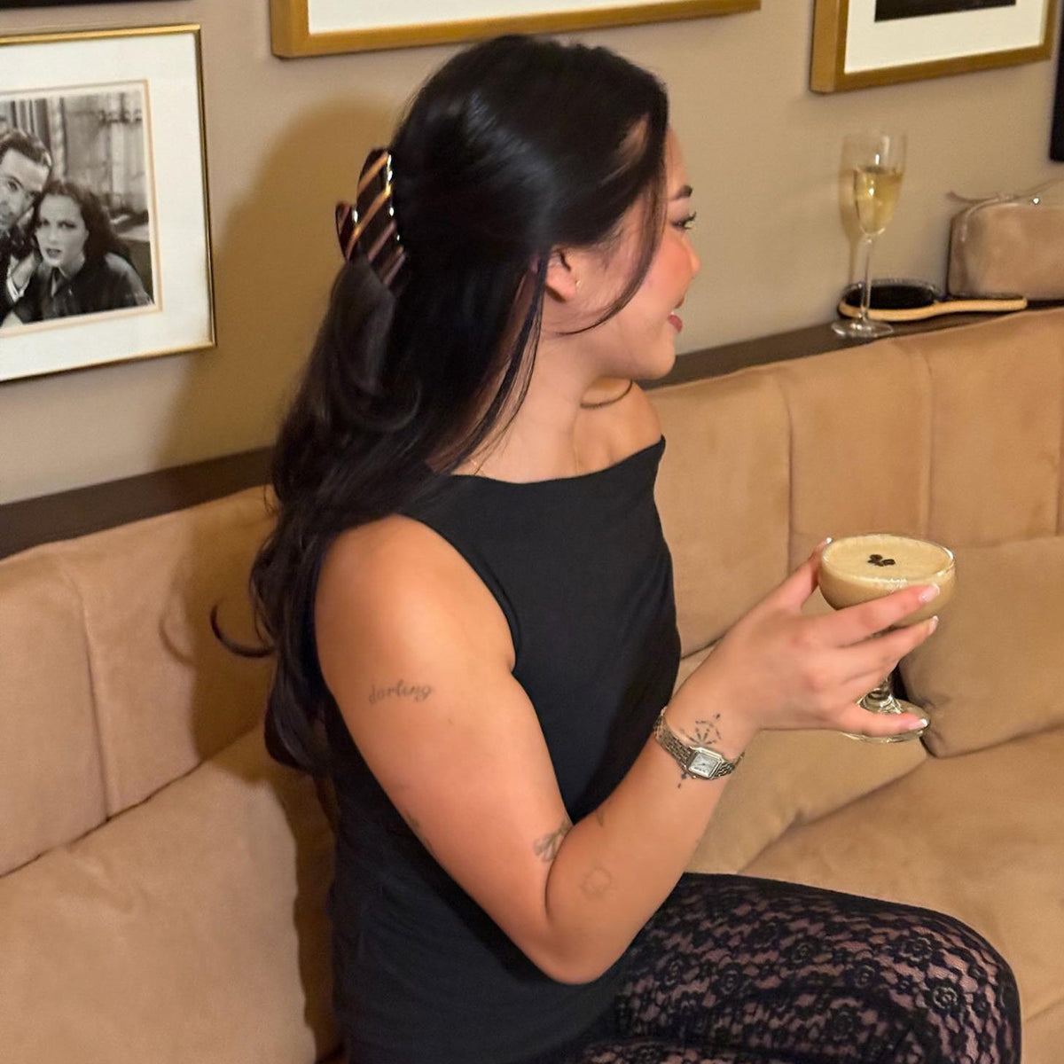 model wearing big effing clip in  nightcap while sitting on couch with espresso martini