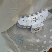 Big Effing Clip in Blanc Fleur Eyelet attached to fabric with embroidered EJ in blue