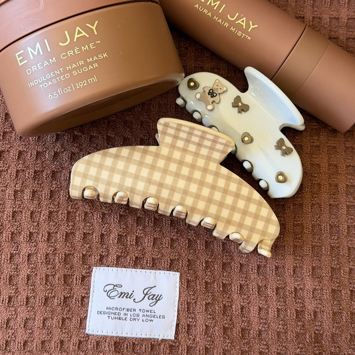 assorted emi jay hair care and accessories on towel