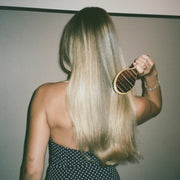 model in polka dot dress brushing hair with Flat Brush in Nightcap