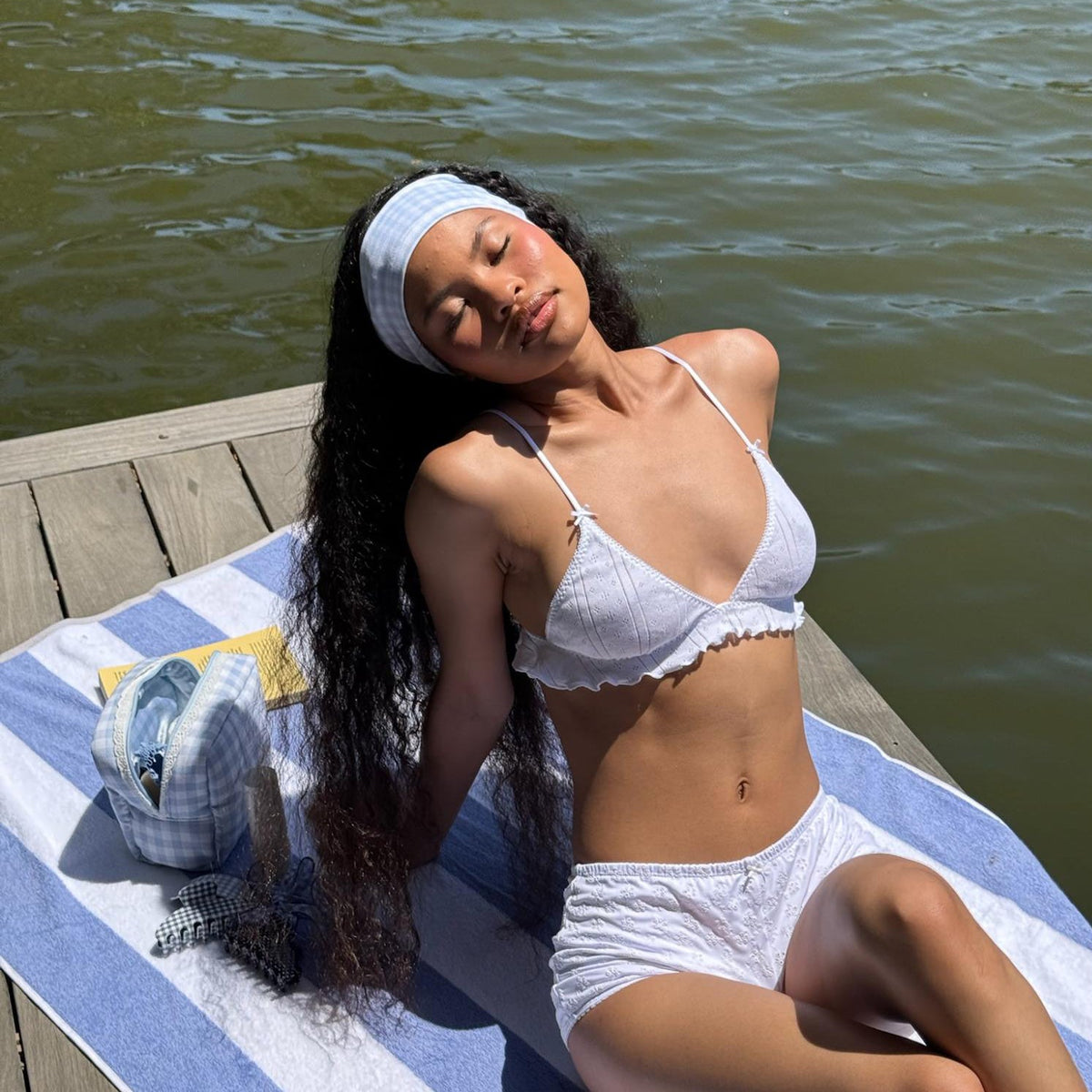 model leaning back in sun on dock while wearing Infinity Headband in Baby Blue Gingham