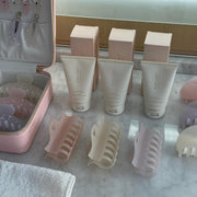 assorted emi jay hair clips and vanity case with multiple bottles of Angel Hold on counter by towel