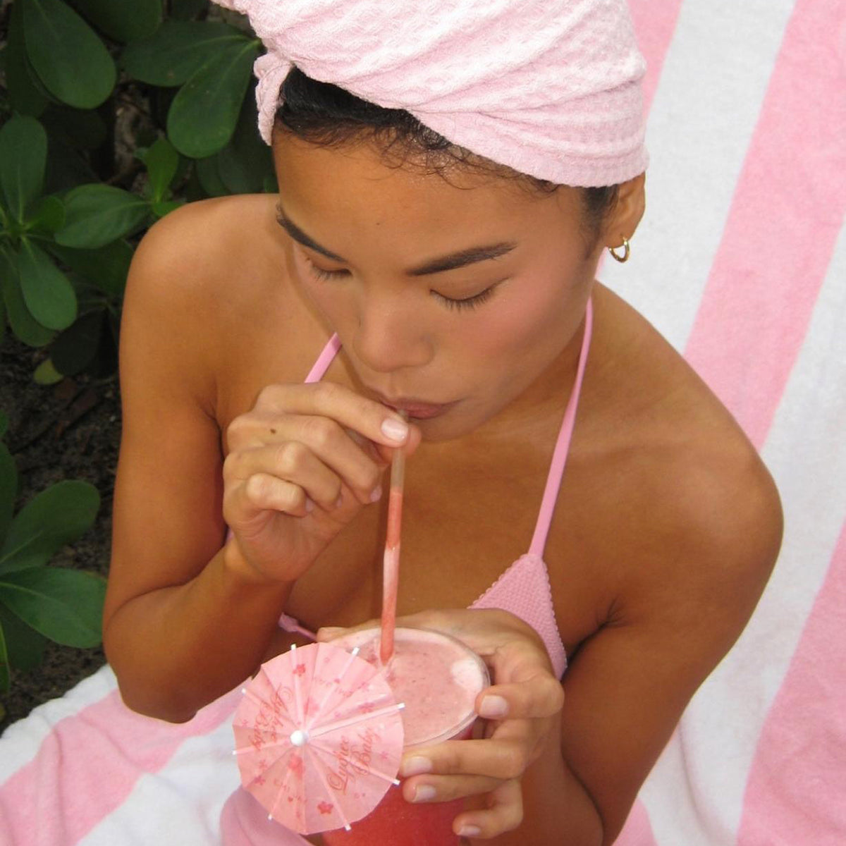 model drinking out of straw while wearing Heavenly Hair Towel in Lychee Baby
