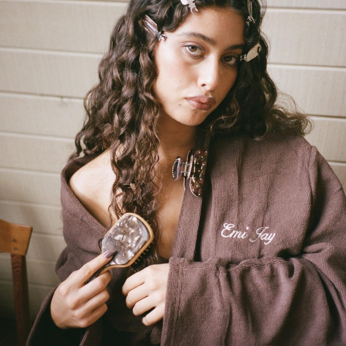 model wearing popstar clips, emi jay robe, and sweetheart clip brushing hair with Mini Bamboo Paddle Brush in Toasted Sugar