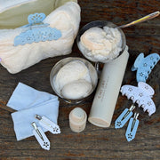 Popstar Clips in Blue Mist Eyelet on table with ice cream in dish, heavenly hair milk, pouch, and hair accessories