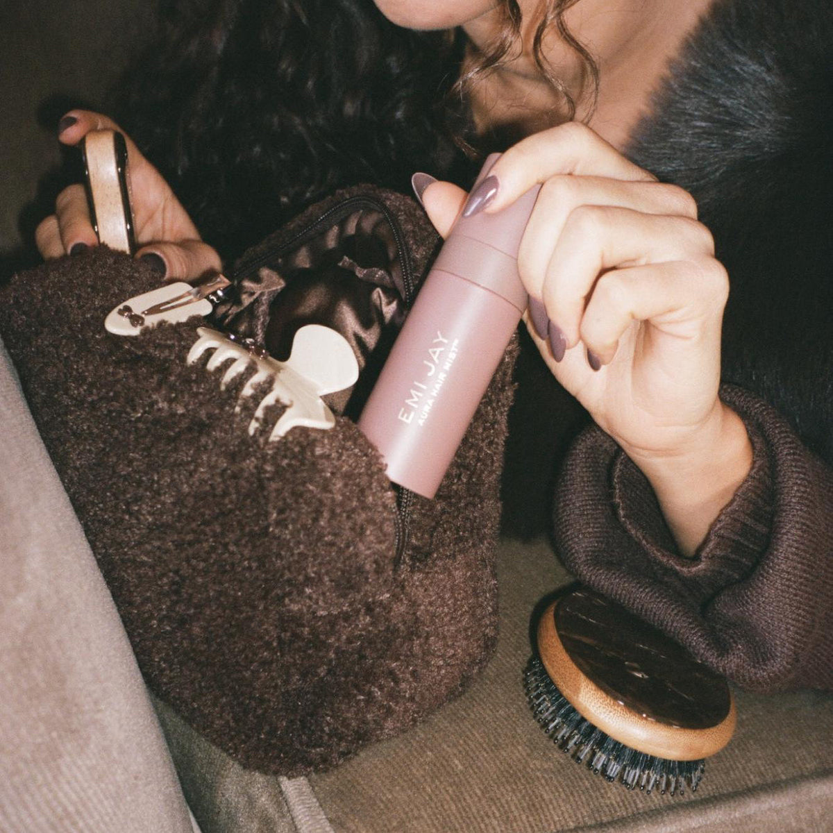 model taking Aura Hair + Body Mist in Toasted Sugar out of Teddy Pouch in Toasted