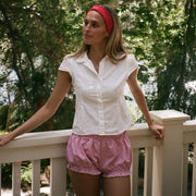 model leaning against railing while wearing Ruffle Headband in Cherry Kiss