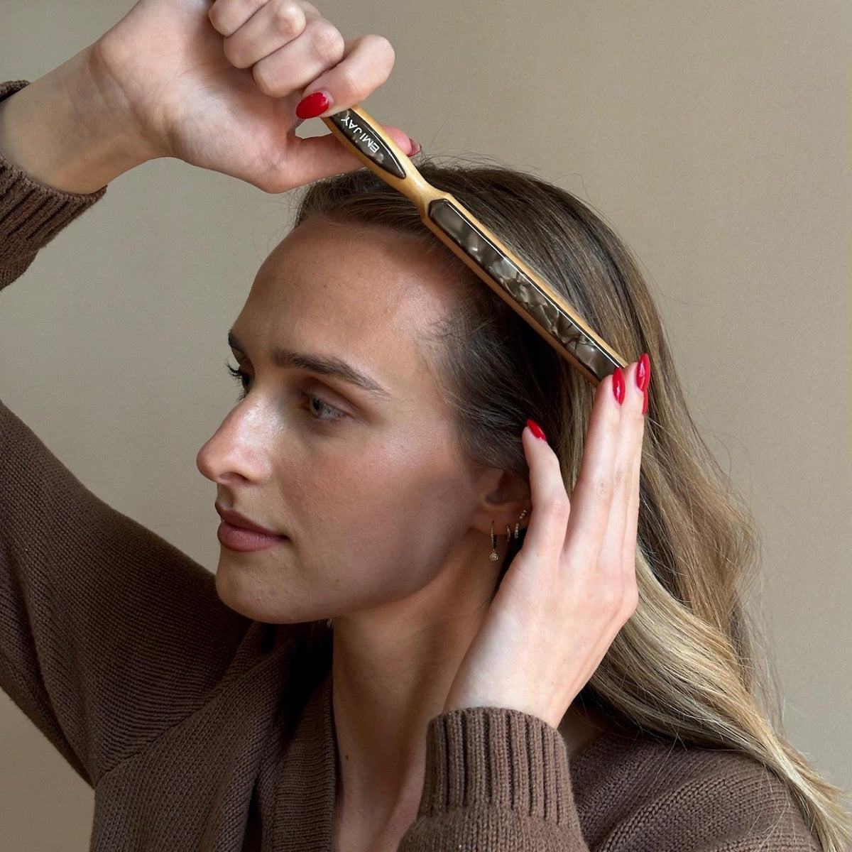 Closeup of model brushing hair with Styling Brush in Toasted Sugar.