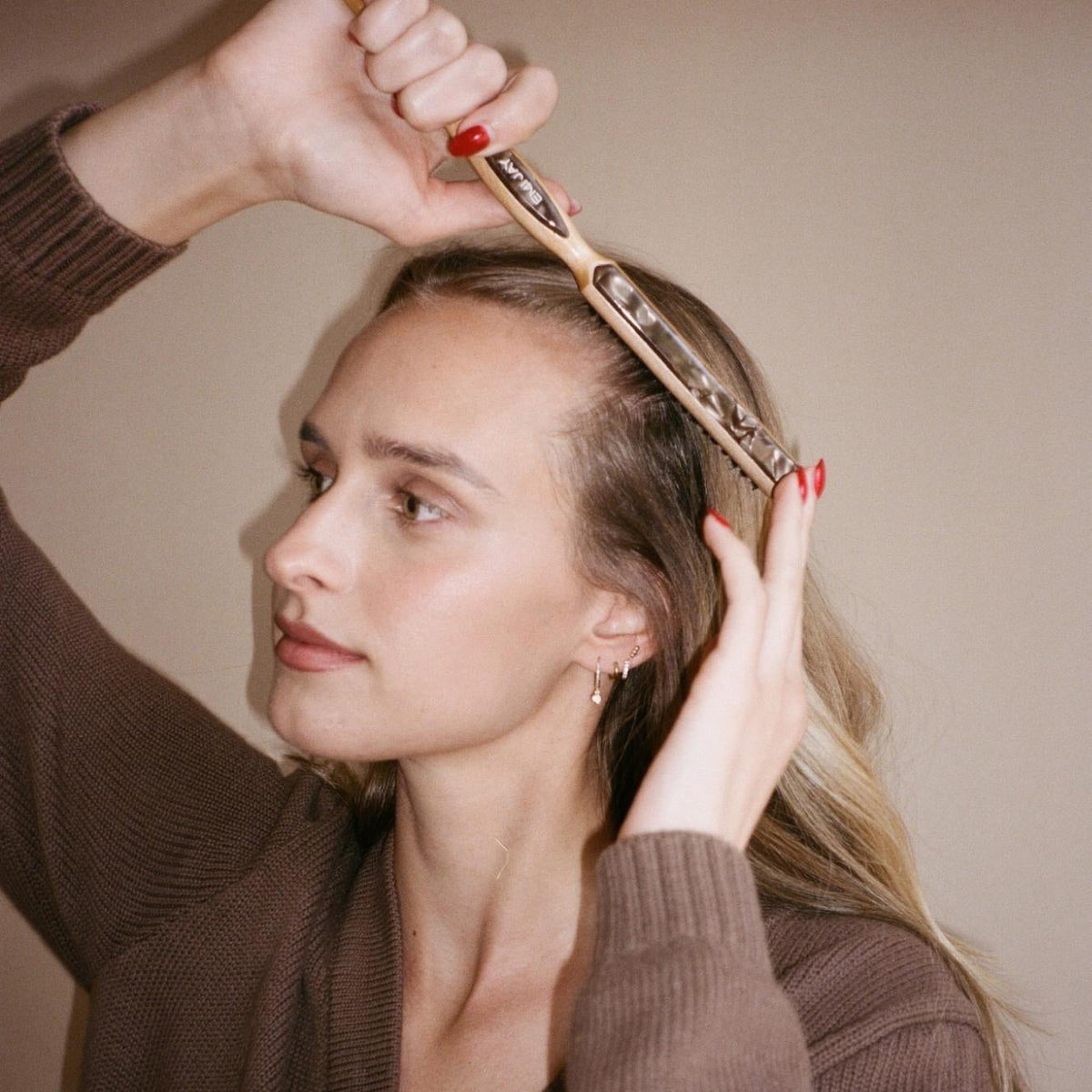 Model using Styling Brush in Toasted Sugar in hair.